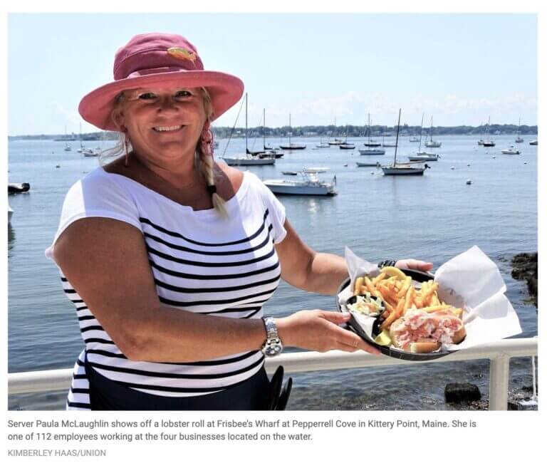 Server at Pepperrell Cove poses with a lobster roll meal